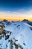 Sonnenuntergang über dem schneebedeckten Gipfel des Nuvolau mit Monte Pelmo und Civetta im Hintergrund, Luftaufnahme, Dolomiten, Venetien, Italien, Europa