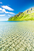 Weißer Sand, gewaschen von türkisfarbenem klarem Meer mit Bergen im Hintergrund, Ersfjord Strand, Senja, Troms County, Norwegen, Skandinavien, Europa
