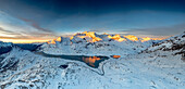 Winding road of Bernina Pass in the winter landscape near the frozen Lago Bianco at sunrise, Engadine, Graubunden, Switzerland, Europe