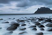 Dunkle Wolken über dem Strand von Uttakleiv und vom Meer gewaschene Steine, Leknes, Vestvagoy, Nordland, Lofoten-Inseln, Norwegen, Skandinavien, Europa