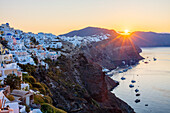 Sonnenaufgang über der Küste von Oia und typischen weißen Gebäuden, Santorini, Kykladen, griechische Inseln, Griechenland, Europa