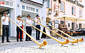 City festival with alphorn blowing with the &quot;Alpen-Hörner&quot; alphorn blowers at Schranneenplatz in Füssen in Ostallgäu in Bavaria in Germany