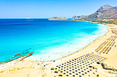 Beach umbrellas and sunbeds on white sand of Falassarna beach overlooking the crystal sea, Kissamos, Chania, Crete, Greek Islands, Greece, Europe
