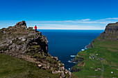 Hiker on The Postman's Trail to the village of Gasaldur, Vagar Island, Faroe Islands, Denmark, Europe