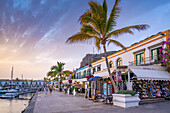 Blick auf Cafés und Restaurants und Palmen im alten Hafen, Puerto de Mogan bei Sonnenuntergang, Gran Canaria, Kanarische Inseln, Spanien, Atlantik, Europa