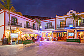 Blick auf Cafés und Restaurants in Puerto de Mogan und bergigen Hintergrund in der Abenddämmerung, Puerto de Mogan, Gran Canaria, Kanarische Inseln, Spanien, Atlantik, Europa