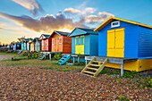 Colourful beach huts on shingle beach at sunrise, Whitstable, Kent, England, United Kingdom, Europe
