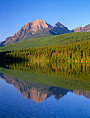 USA, Montana, Glacier National Park, Rainbow Peak (left) reflects in Bowman Lake.