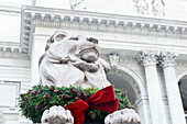 New York City, New York, USA. Steinlöwe geschmückt für die Feiertage auf der 5th Avenue.
