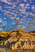Dramatic sunrise clouds over badlands formations in Theodore Roosevelt National Park, North Dakota, USA.