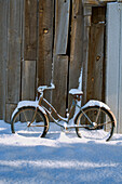 USA, Oregon, Bend. An old bicycle sits covered in snow near a barn in Bend, Oregon.
