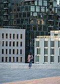 Touristin genießt die Aussicht auf die Skyline des Barcode Viertel vom Dach des Opernhauses in Oslo, Norwegen.