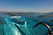 Infinity-Pool und Blick über Berge und See und die Stadt Luzern an einem sonnigen Sommertag vom Bürgenstock Resort, Nidwalden, Schweiz.