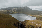 Scenic view remote mountain lake and waterfall, Wailing Widow, Assynt, Scotland
