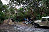 SUV geparkt vor dem Zelt auf dem Campingplatz zwischen Bäumen, Wilsons Prom, Victoria, Australien