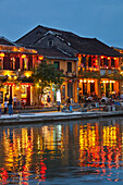 Restaurants reflected in Thu Bon River at dusk, Hoi An (UNESCO World Heritage Site), Vietnam