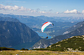 Europe, Austria, Dachstein, Paraglider soaring above Lake Hallstatt and the surrounding mountains, all of which is part of the Salzkammergut Cultural Landscape, UNESCO World Heritage Site