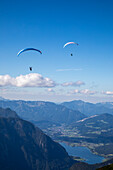 Europe, Austria, Dachstein, Paragliders as they soar above Lake Hallstatt and the surrounding mountains, all of which is part of the Salzkammergut Cultural Landscape, UNESCO World Heritage Site