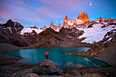Argentina, Los Glaciares National Park. Hiker taking in Mt. Fitz Roy and Laguna de los Tres at sunrise. (MR)