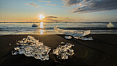 Europe, Iceland. Morning light shines on ice chunks on Diamond Beach near Jokulsarlon glacial lagoon on the south coast.