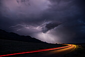 USA, Colorado, oberes Arkansas River Valley. Blitzsturm über Fahrzeuglichtspur