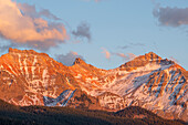 USA, Colorado. Uncompahgre National Forest, sunset light on Vermillion Peak above autumn evergreen forest, view east from above Trout Lake.