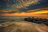 USA, New Jersey, Cape May National Seashore. Sonnenuntergang auf Ozean und Felsen