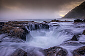 USA, Oregon. Thor's Well and ocean at sunset
