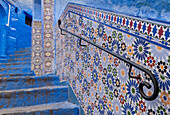 Africa, Morocco, Chefchaouen. Decorated tile wall of stairway.