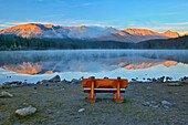 Kanada, Alberta, Jasper-Nationalpark. Bank mit Blick auf den See und die Berge bei Sonnenuntergang.