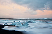Europa, Island, Gletscherlagune Jokulsarlon. Die Wellen umspülen gestrandete Eisberge.