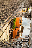 Italien, Rom. Via della Penna, Seitenstraße westlich der Via Ripetta, ein paar Blocks unterhalb der Piazza del Popolo mit Regenpfützen und Spiegelungen.