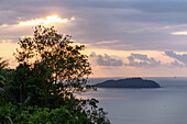 dramatischer Abendhimmel mit Sonnenuntergang hinter Wolken und Blick auf Bom Bom Island vor der Insel Príncipe in Westafrika, Sao Tomé e Príncipe