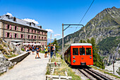 Die rote Zahnradbahn vom Mer de Glace fährt am Hotel-Restaurant Montenvers vorbei, Chamonix-Mont-Blanc, Auvergne-Rhone-Alpes, Frankreich