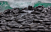 Wellen, die am Giant's Causeway in der Grafschaft Antrim, Nordirland, in Basalt einschlagen