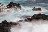 Wellen über Lavafelsen an der Küste der Insel Espanola, Galapagos-Inseln, Ecuador.
