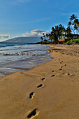 Footprints in the sand evening light along Kamaole Beach Park II, Kihei Maui, Hawaii.
