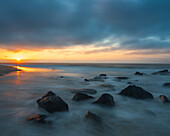 USA, New Jersey, Cape May National Seashore. Sunrise on rocky shoreline.