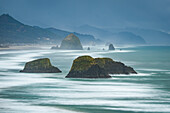 USA, Oregon, Kanonenstrand. Langzeitbelichtung von Strand- und Meeresstapeln.
