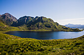 Norway, Lofoten, green hills in the sunshine by a fjord