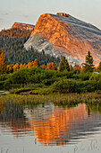 Tuolumne Meadows and Lembert Dome reflected in Tuolumne River, Yosemite National Park, California at sunset.