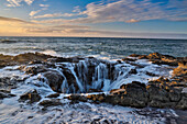 Thor's Well with surf cascading into the well along the Oregon coastline