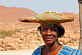Namibia; Region Kunene; Zentralnamibia; am Ugab Fluss; Herero Frau in traditioneller Kleidung und mit typischer Kopfbedeckung