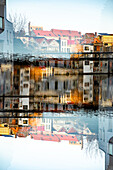 Double exposure photo of buildings reflected in water in Gent, Belgium