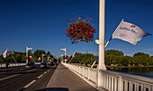 Pont de Bellerive over Lac d´Allier with the flags of the UNESCO Major European Spas and a view towards Parc Kennedy, Vichy, Auvergne-Rhône-Alpes, France