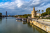 Am Ufer des Fluss Guadalquivir mit dem historischen Turm Torre del Oro in Sevilla, Andalusien, Spanien  