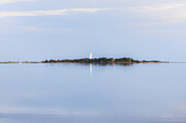 Langer Erik lighthouse from afar on the Norra Udde peninsula. reflection in the water. Oland, Sweden.