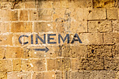 Italy, Basilicata, Province of Matera, Matera. Sign on a wall pointing to a cinema, movie theater.