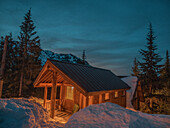 USA, Bundesstaat Washington, Pierce County, Crystal Mountain Resort, Gold Hills. Skihütteneingang in der Winternacht beleuchtet.