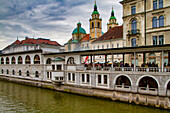 Buildings and covered market at the river under clouded sky, Ljubljana, capital of Slovenia, Europe.